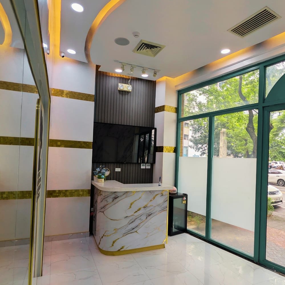 The Better Face reception: a gold-veined marble desk, gold-trimmed walls and tall green-framed windows onto the street