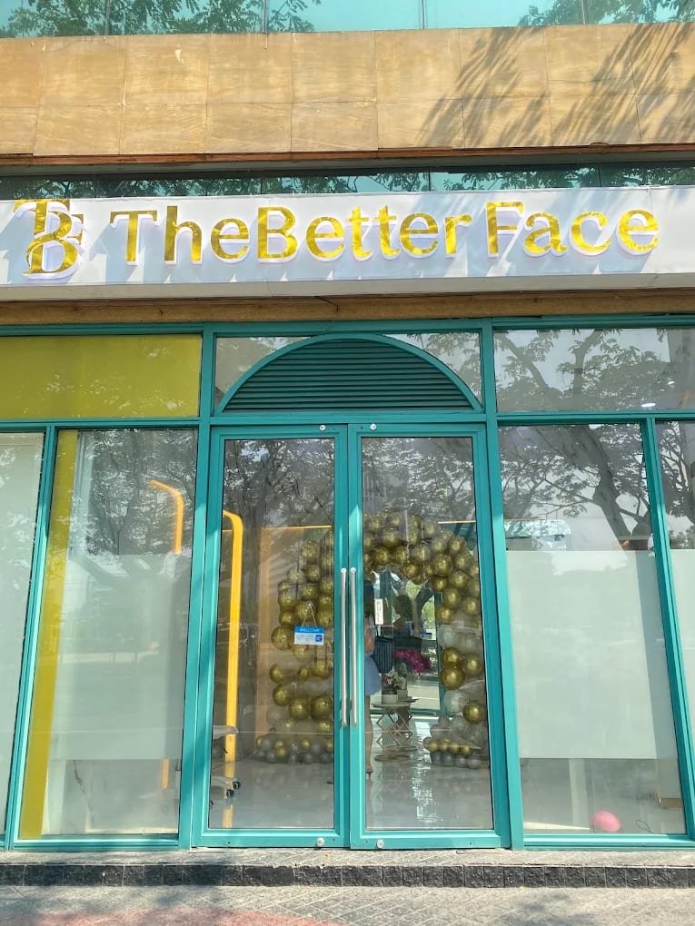 The Better Face clinic entrance: the gold The Better Face sign above teal-framed glass doors